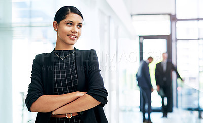 Buy stock photo Cropped shot of an attractive young businesswoman looking thoughtful while standing in an office with her colleagues in the background