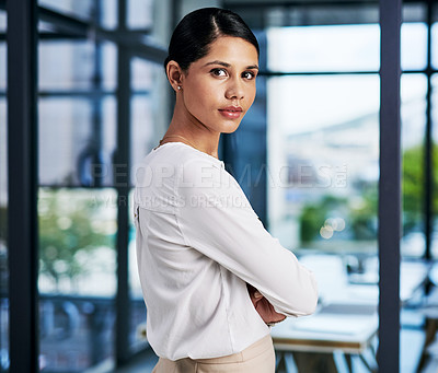 Buy stock photo Cropped portrait of an attractive young businesswoman standing with her arms folded in a modern office