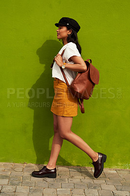 Buy stock photo Full length shot of an attractive young woman walking against a green background during a day out in the city