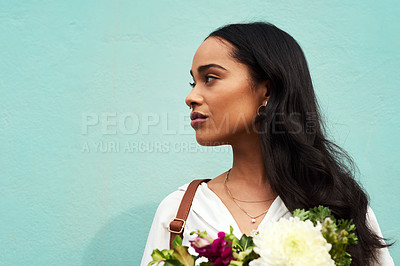 Buy stock photo Cropped shot of an unrecognizable woman standing alone and holding a bouquet of flowers against a blue background