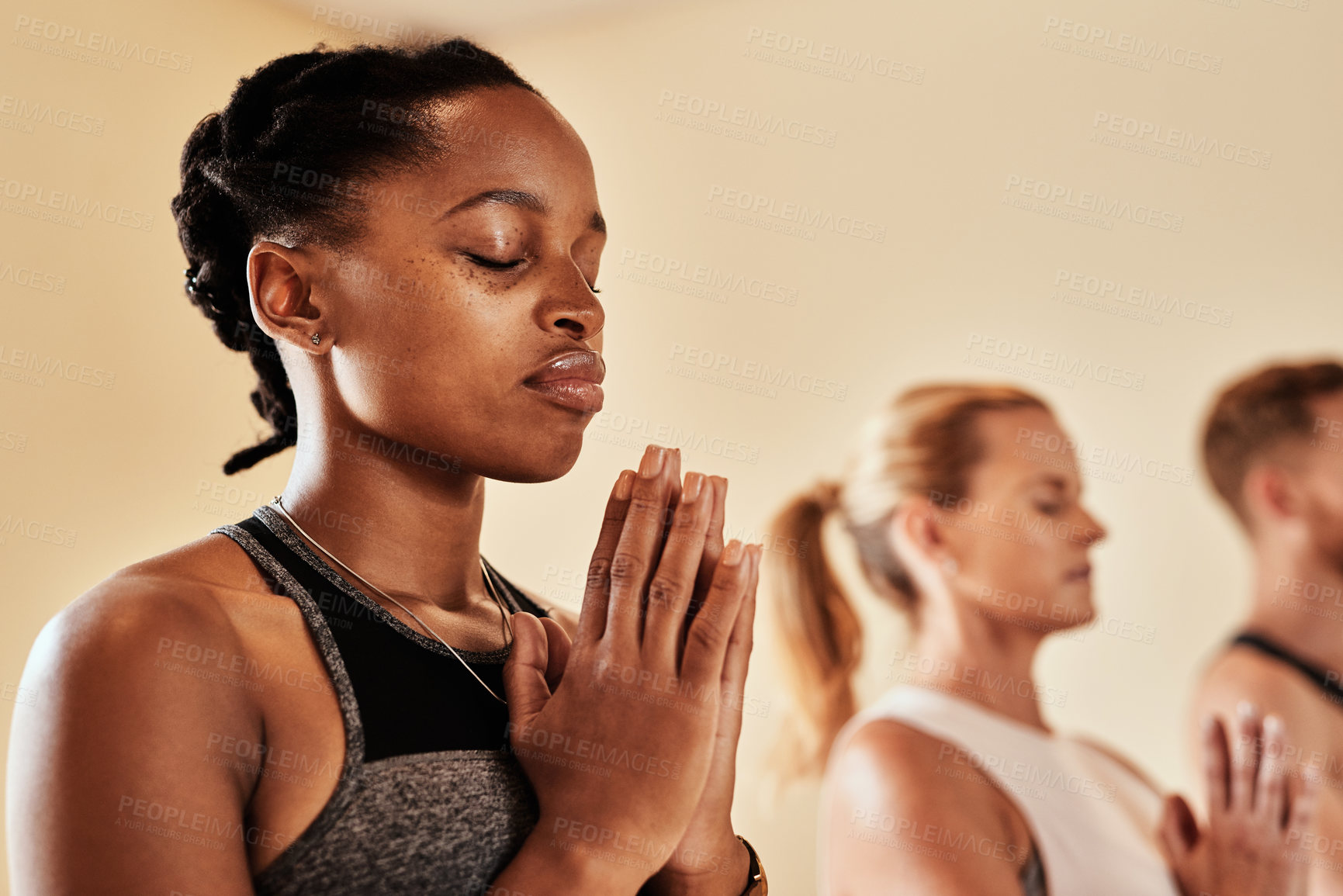 Buy stock photo Shot of a group of young men and women meditating in a yoga class