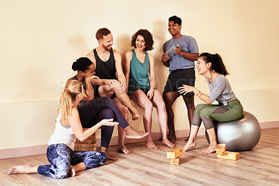 Buy stock photo Shot of a group of young men and women hanging out in yoga class 
