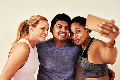 Buy stock photo Shot of a group of young men and women taking selfies in yoga class 