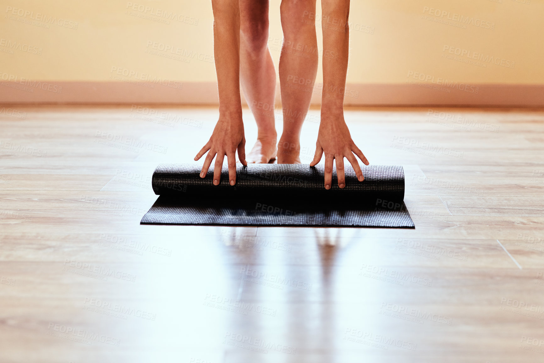 Buy stock photo Cropped shot of a woman rolling out her yoga mat
