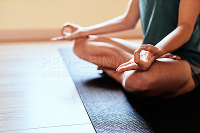 Buy stock photo Cropped shot of a woman meditating in the lotus position during a yoga session
