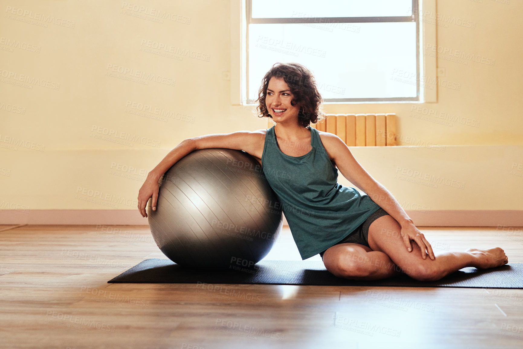 Buy stock photo Shot of a young woman working out with a stability ball during a yoga session