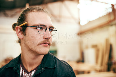 Buy stock photo Cropped shot of a handsome young carpenter working inside his workshop