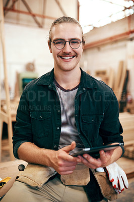 Buy stock photo Portrait of a handsome young carpenter using a digital tablet while working inside his workshop