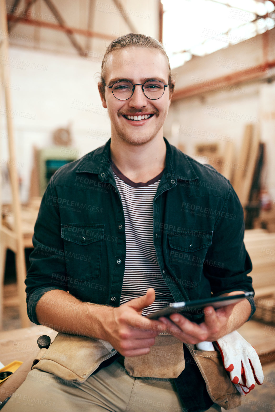 Buy stock photo Portrait of a handsome young carpenter using a digital tablet while working inside his workshop