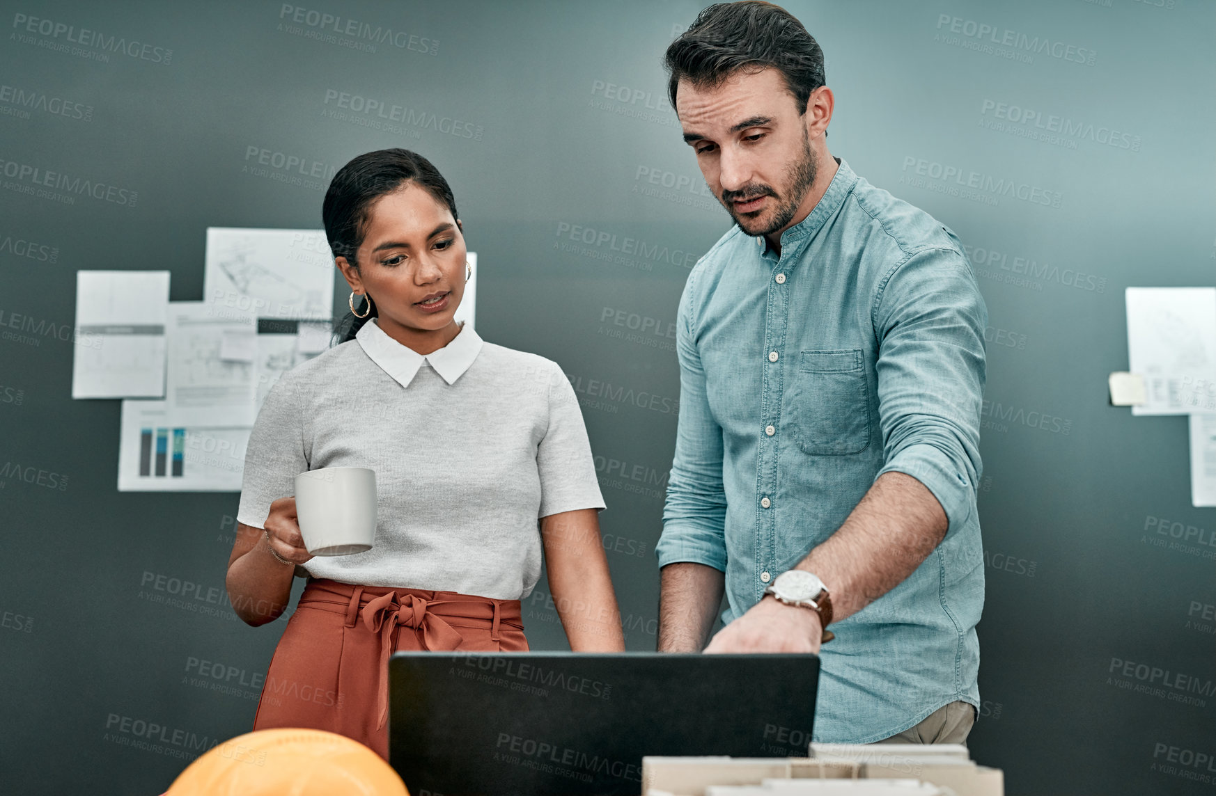 Buy stock photo Shot of two architects working together on a laptop in an office