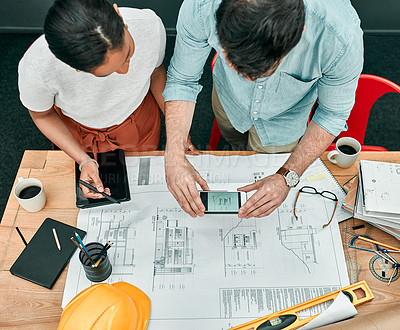 Buy stock photo Shot of two architects using a cellphone to take photos of blueprints in an office