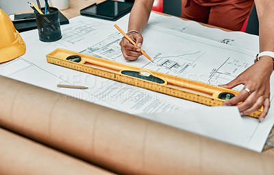 Buy stock photo Closeup shot of an unrecognisable architect working with blueprints in an office