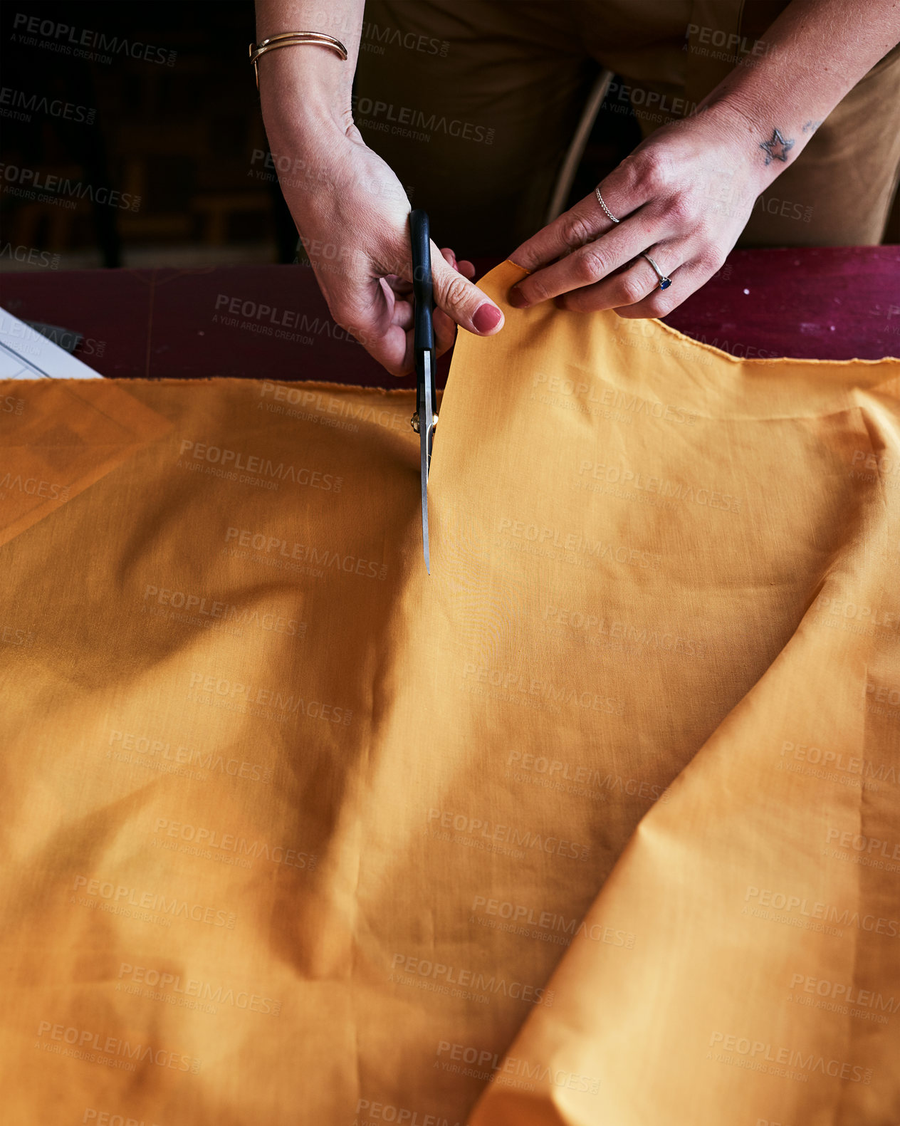 Buy stock photo Cropped shot of an unrecognizable fashion designer cutting fabric