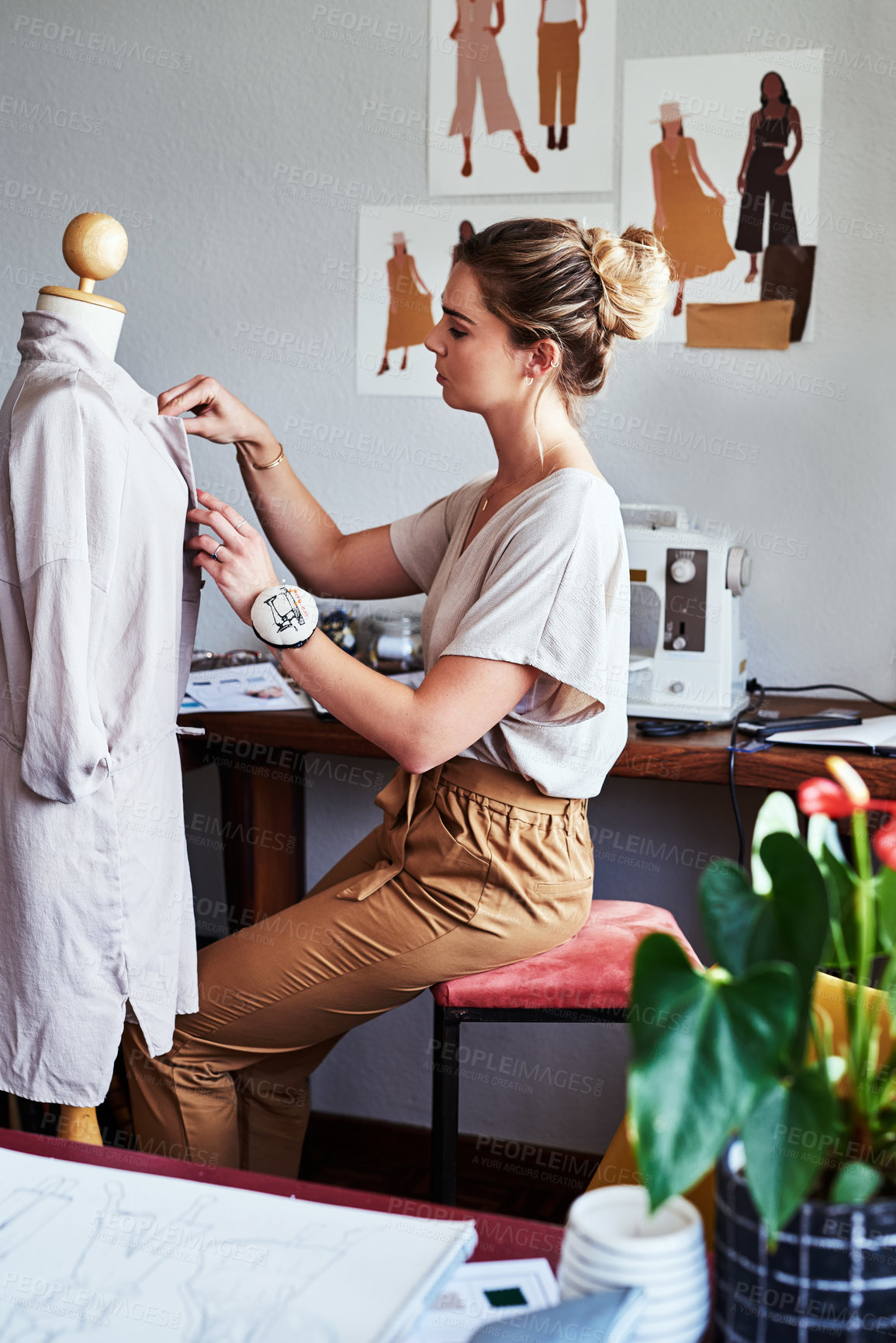 Buy stock photo Shot of a young fashion designer working on a garment hanging over a mannequin