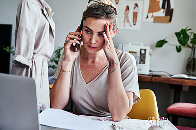 Buy stock photo Shot of a young designer looking stressed while talking on her cellphone
