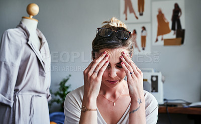 Buy stock photo Cropped shot of a fashion designer looking stressed at her desk