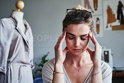 Buy stock photo Cropped shot of a fashion designer looking stressed at her desk
