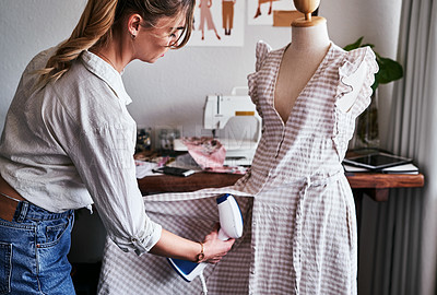 Buy stock photo Shot of a fashion designer using  a garment steamer in her workshop