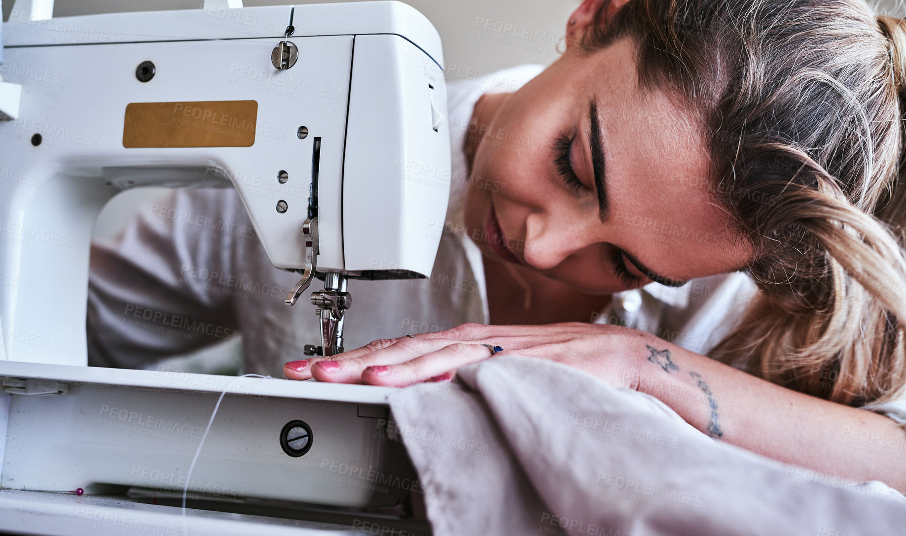 Buy stock photo Fashion, design and closeup of woman at sewing machine, small business ideas, creativity and focus in studio. Creative startup, textile designer or tailor stitching fabric, young entrepreneur at work