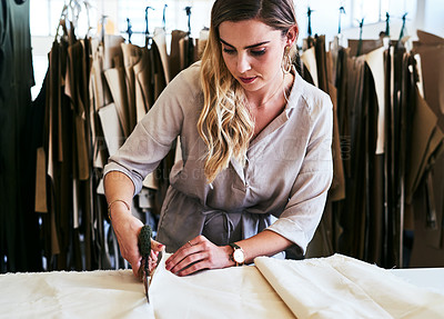 Buy stock photo Cropped shot of a young fashion designer cutting fabric in her workshop