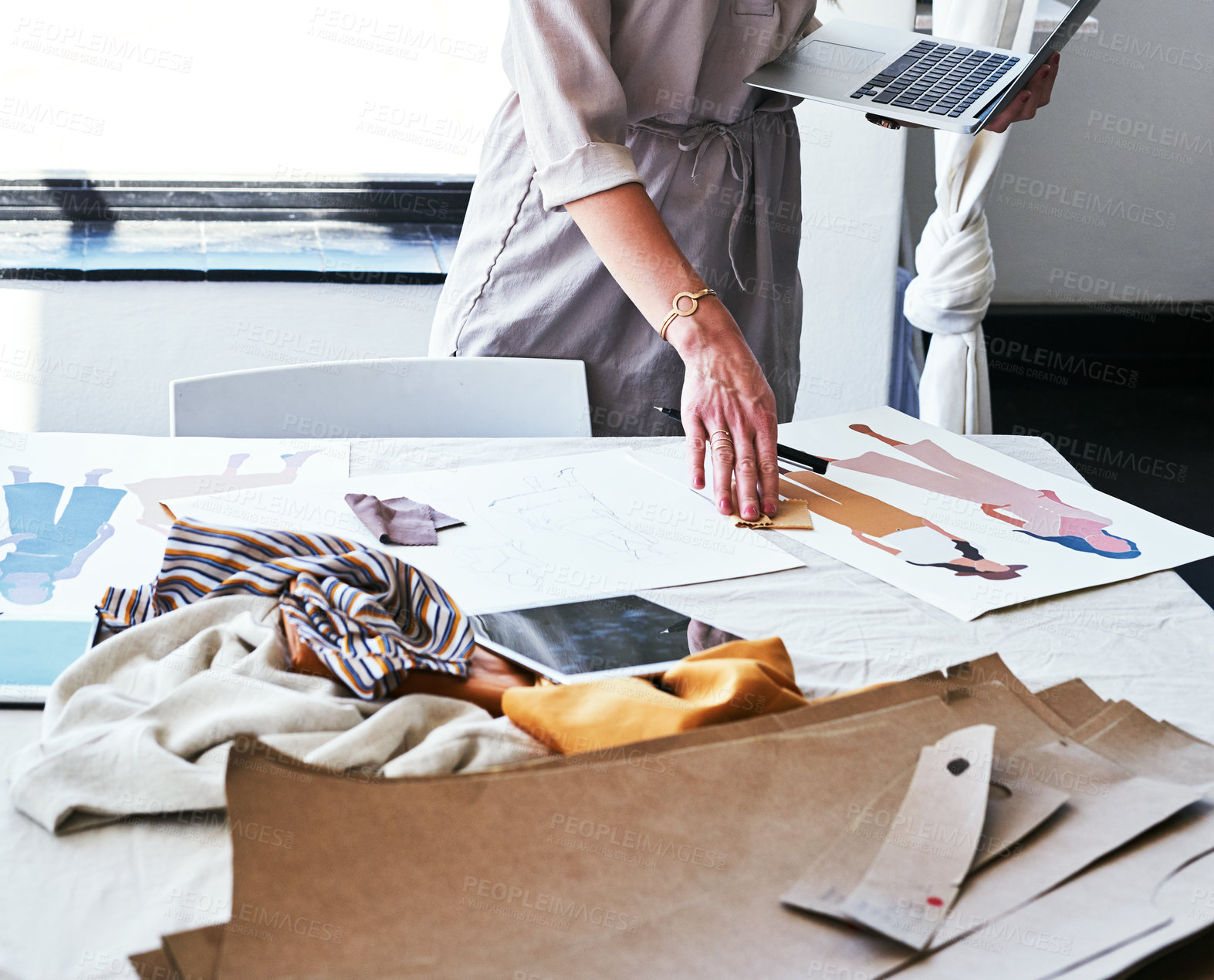 Buy stock photo Cropped shot of a fashion designer working on new designs at her desk
