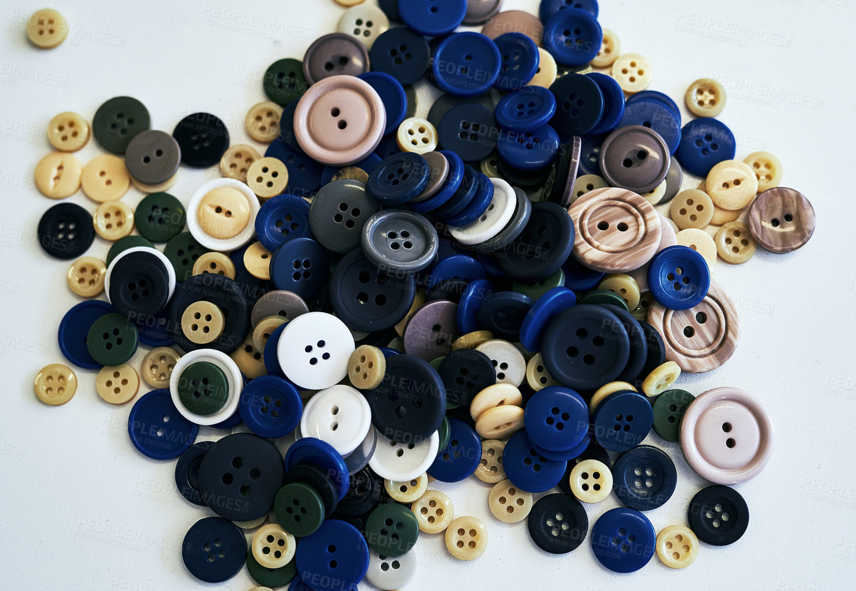 Buy stock photo Shot of sewing buttons laying on a white background