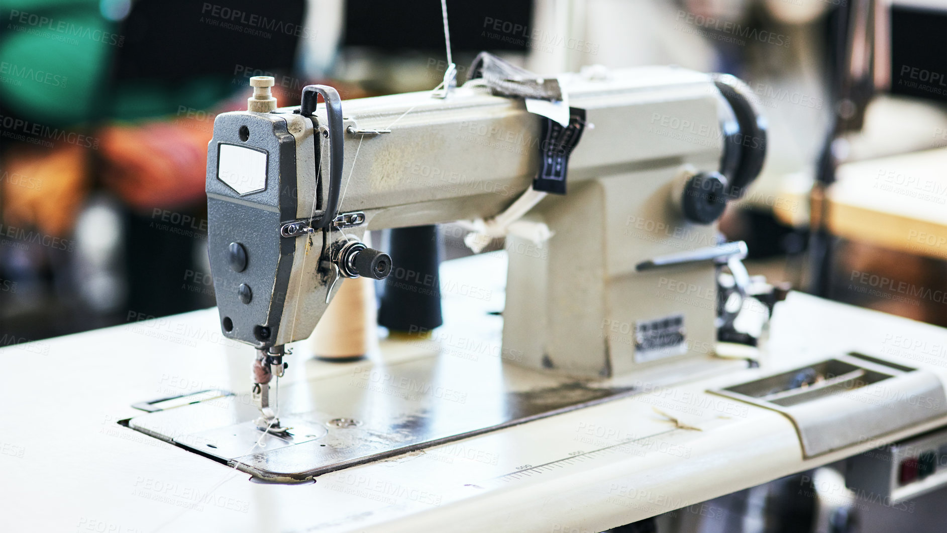 Buy stock photo Sewing machine, needle and cotton thread for fashion in workshop for manufacturing clothes for design. Creative, tailoring and fabric equipment with material for stitches in production at factory.