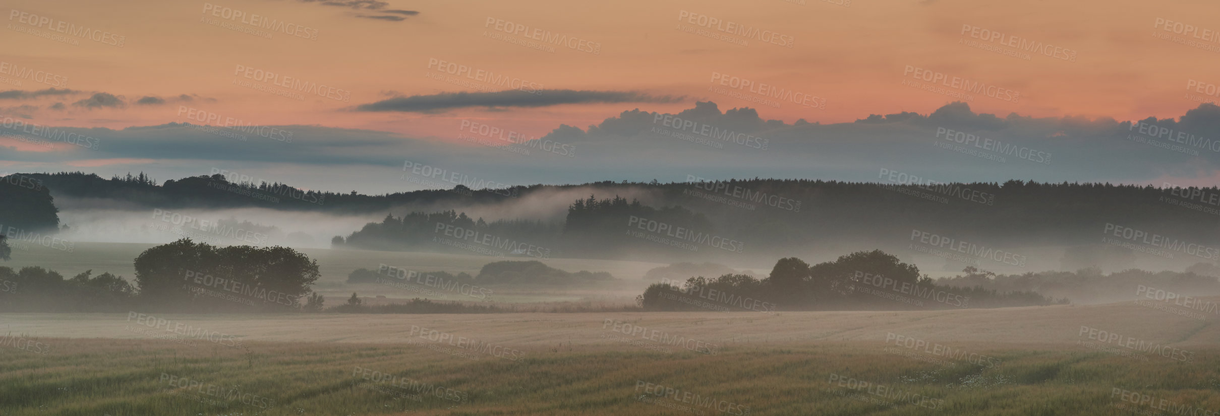 Buy stock photo Landscape view of fog over remote field with copy space at sunset. Mist covering a vast expanse of countryside meadow in Germany at dawn. Smoke from wildfire or bush fires rolling over nature reserve