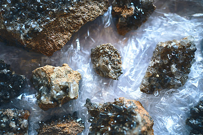Buy stock photo Closeup of a bunch of crystals placed next to each other on a table covered in plastic inside during the day
