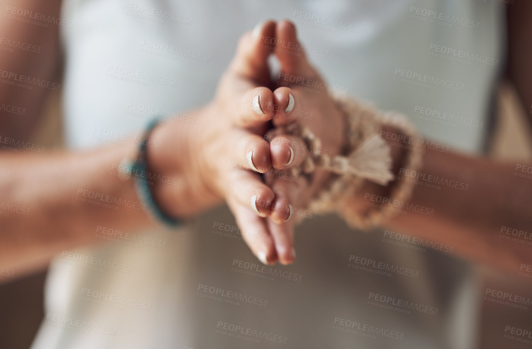 Buy stock photo Cropped shot of an unrecognizable woman standing with her palms together while meditating indoors