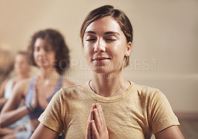 Buy stock photo Cropped shot of a young group of women sitting together and meditating after an indoor yoga session