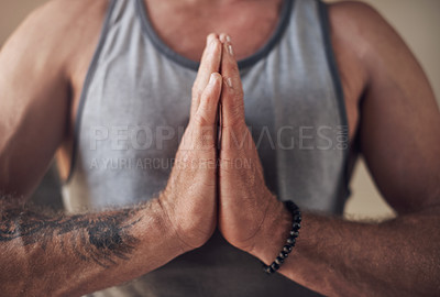 Buy stock photo Cropped shot of an unrecognizable man sitting with his palms together while meditating indoors