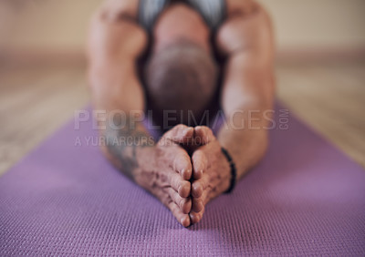 Buy stock photo Cropped shot of an unrecognizable man holding a child's pose during an indoor yoga session alone