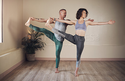 Buy stock photo Full length shot of two young yogis standing together and holding a yoga pose during an indoor session indoors