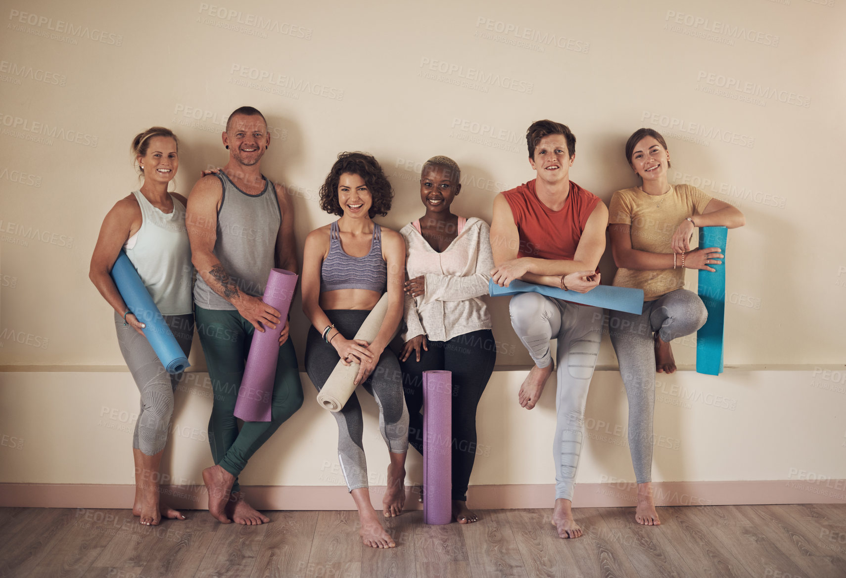 Buy stock photo Full length portrait of a diverse group of yogis sitting together and bonding after an indoor yoga session