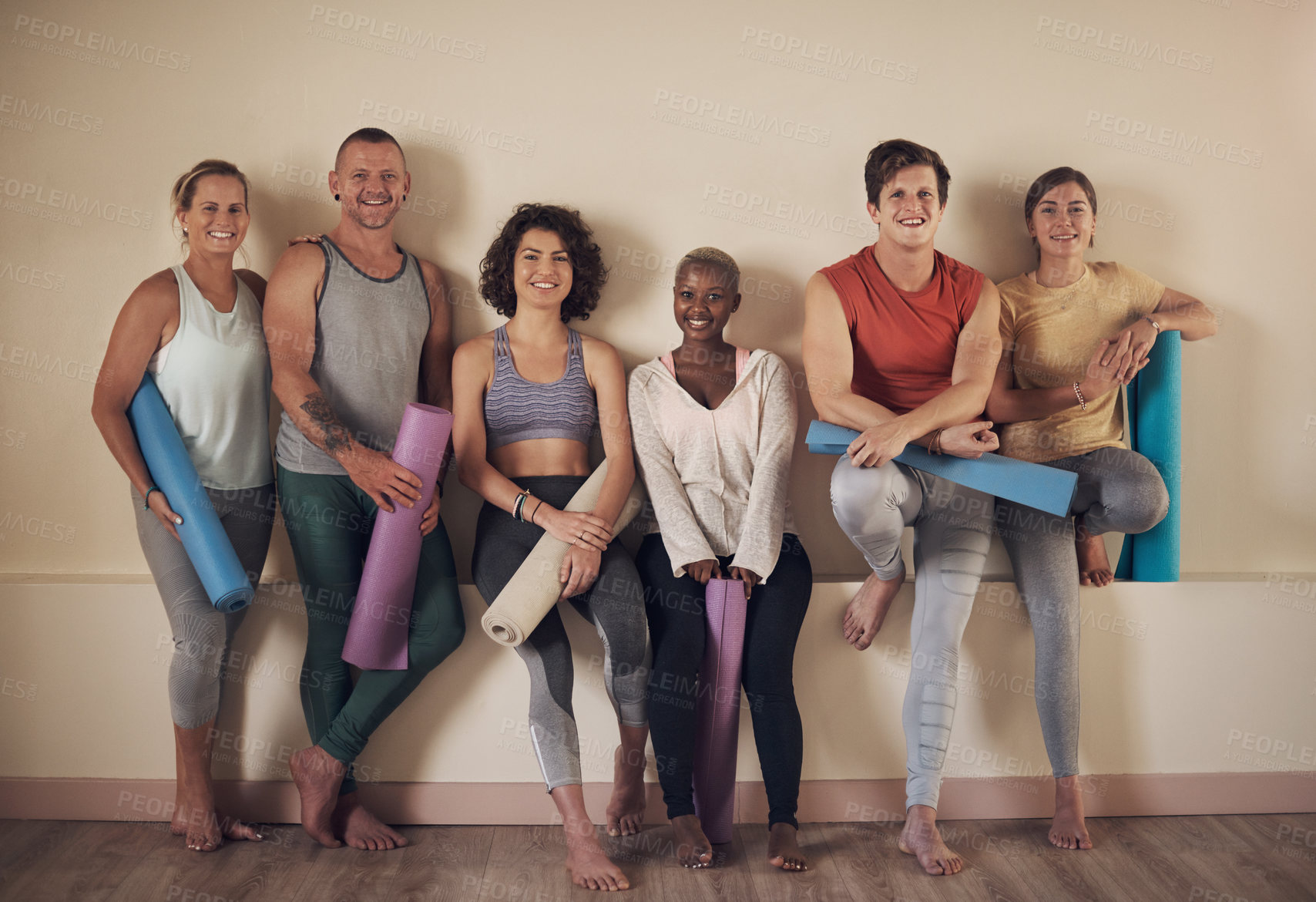 Buy stock photo Full length portrait of a diverse group of yogis sitting together and bonding after an indoor yoga session