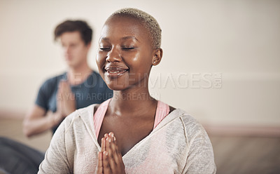 Buy stock photo Cropped shot of an attractive young woman sitting and meditating after a yoga class indoors