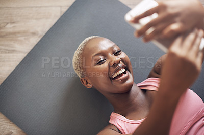 Buy stock photo Cropped shot of an attractive young woman using her cellphone to take a selfie after a yoga session indoors