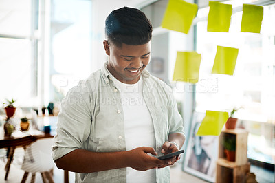 Buy stock photo Happy man, typing and phone with glass board for communication, planning or tasks at office. Male person or creative employee with smile on mobile smartphone for online chatting or texting in startup