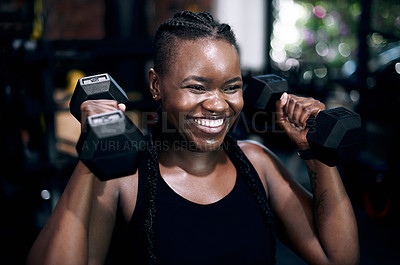 Buy stock photo Cropped shot of an attractive young female athlete working out with dumbbells in the gym