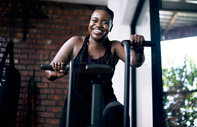 Buy stock photo Cropped portrait of an attractive young female athlete working out on an elliptical machine in the gym