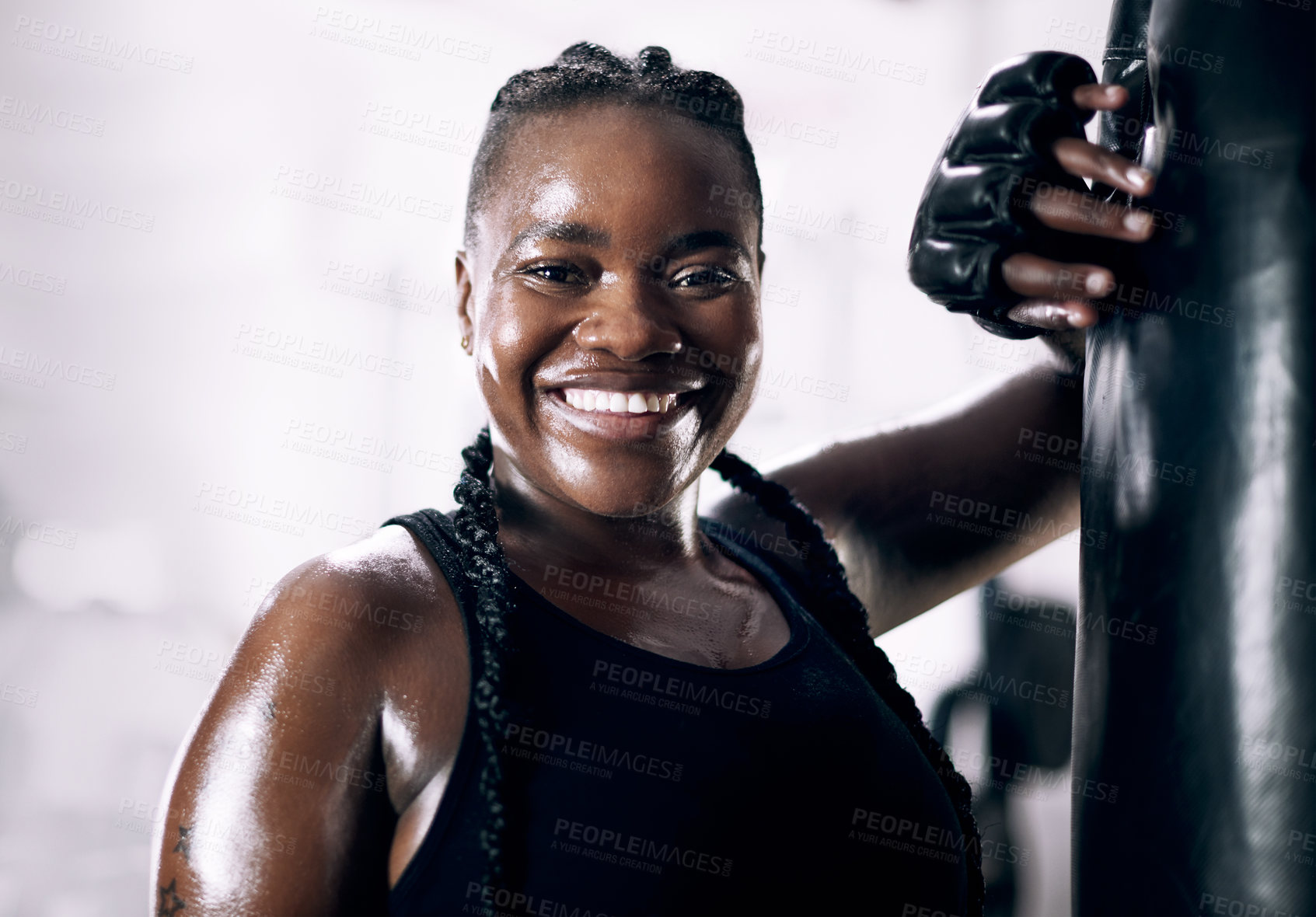 Buy stock photo Cropped portrait of an attractive young female athlete leaning against a boxing bag in the gym