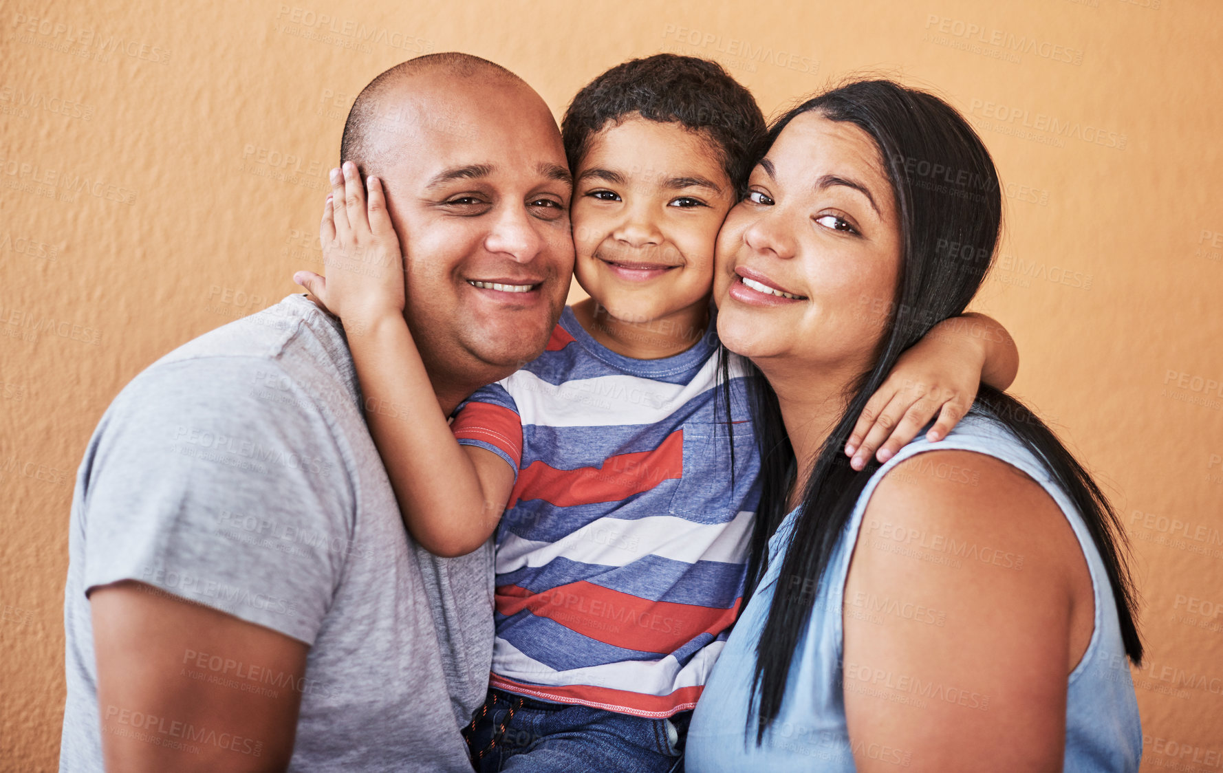 Buy stock photo Cropped shot of a cheerful young couple holding their son while smiling at the camera at home during the day