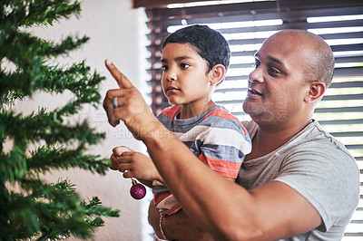 Buy stock photo Dad, Christmas and kid with decoration on tree for festive season, December tradition and creativity. Little, boy and father with ornament in living room at home for helping, support and bonding