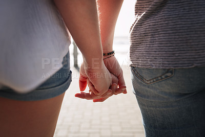 Buy stock photo Cropped shot of an unrecognizable couple holding hands while on a date together outdoors