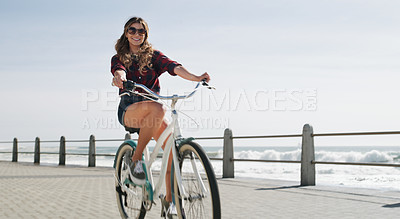 Buy stock photo Shot of a beautiful woman out on the promenade with her bicycle