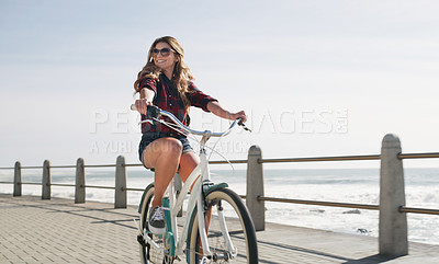 Buy stock photo Shot of a beautiful woman out on the promenade with her bicycle