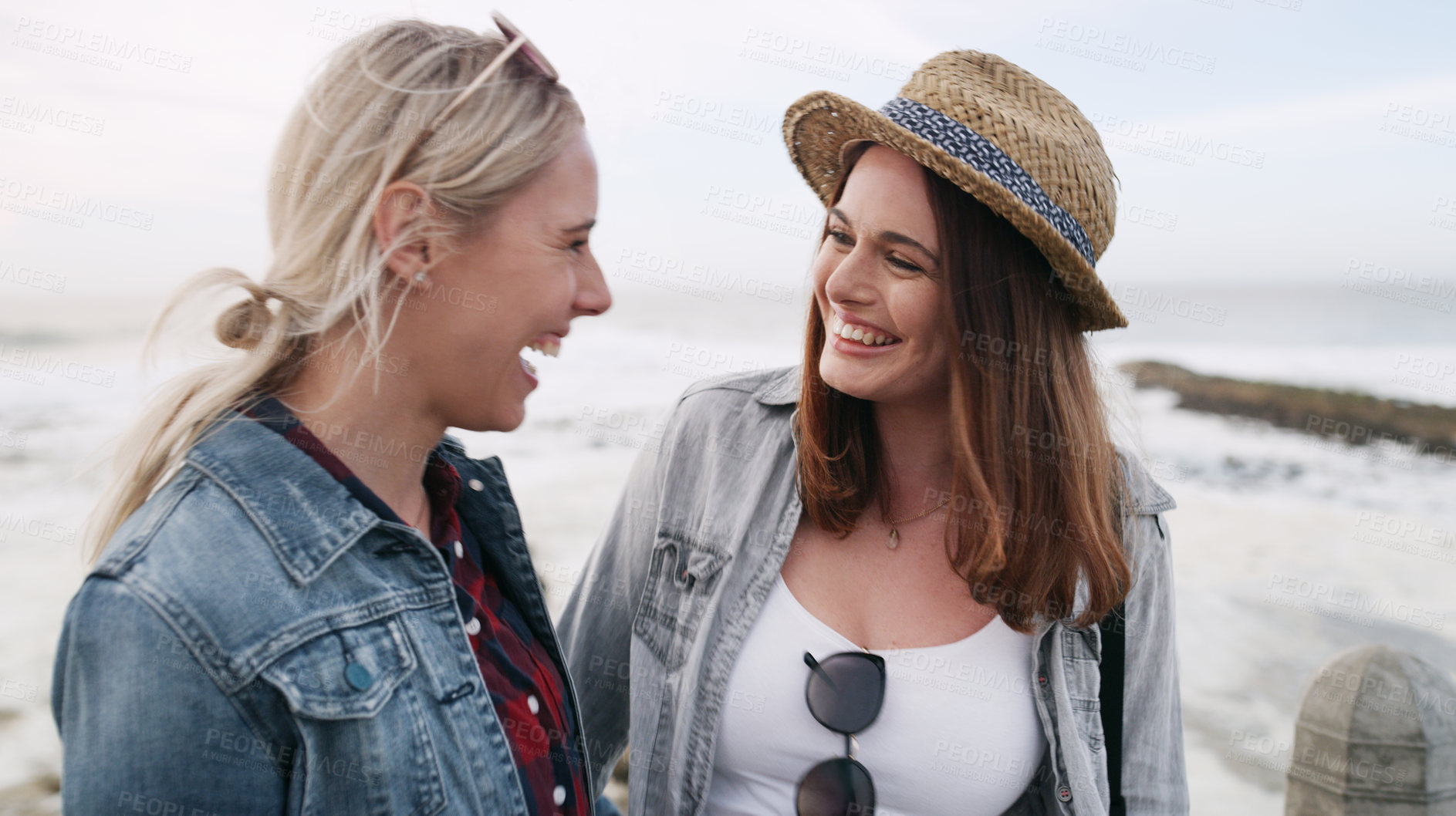 Buy stock photo Shot of a happy young couple bonding and spending the day together outdoors near the beach