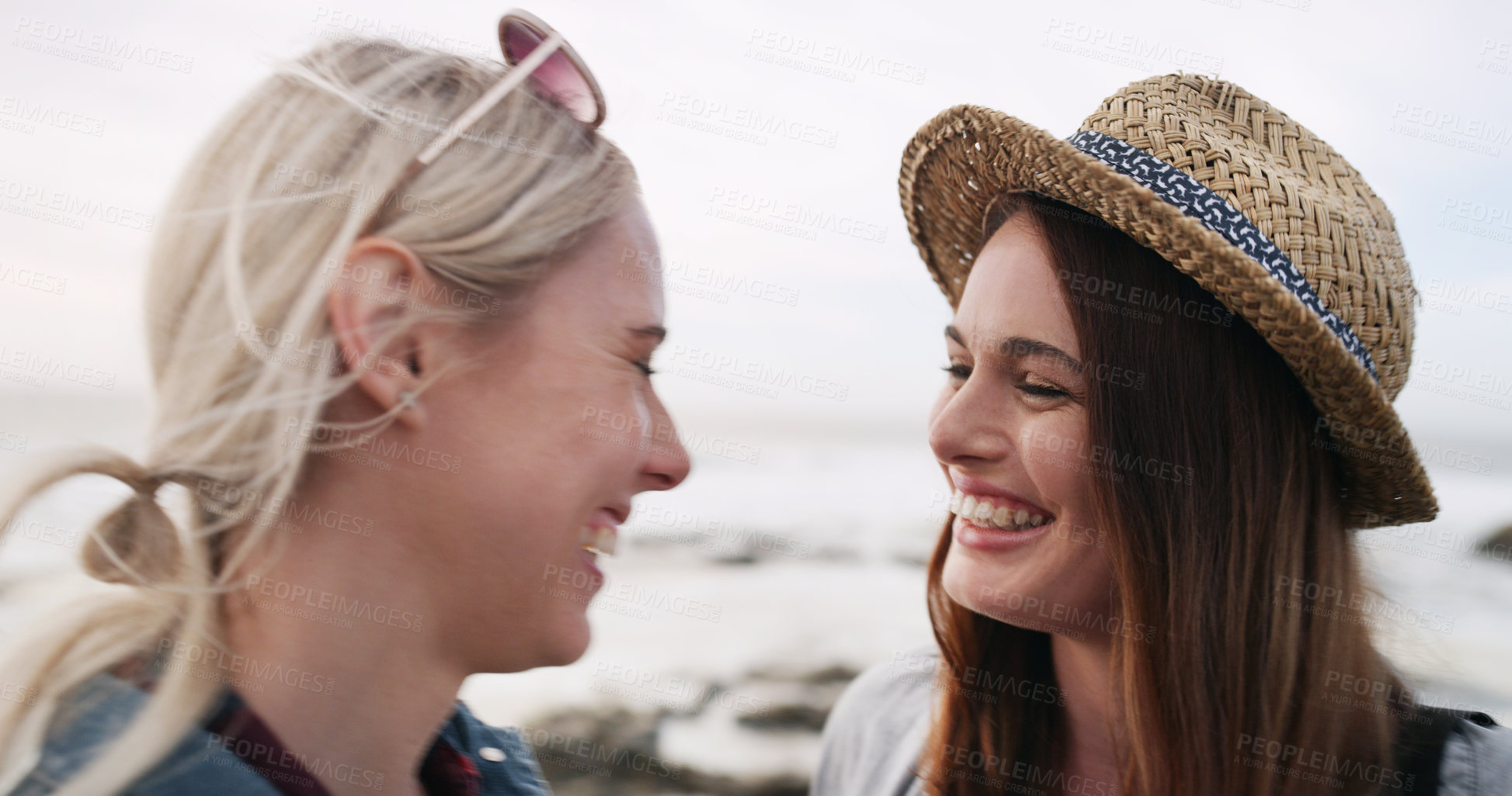 Buy stock photo Shot of a happy young couple bonding and spending the day together outdoors near the beach