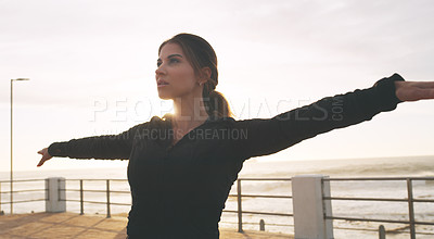 Buy stock photo Shot of a woman practising yoga on the promenade